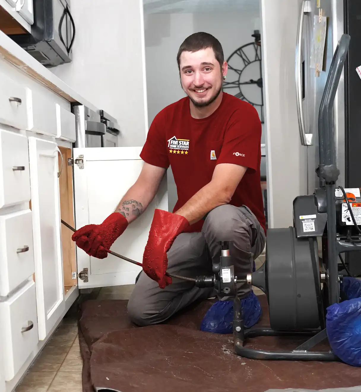 Plumber under a sink with plumbing equipment