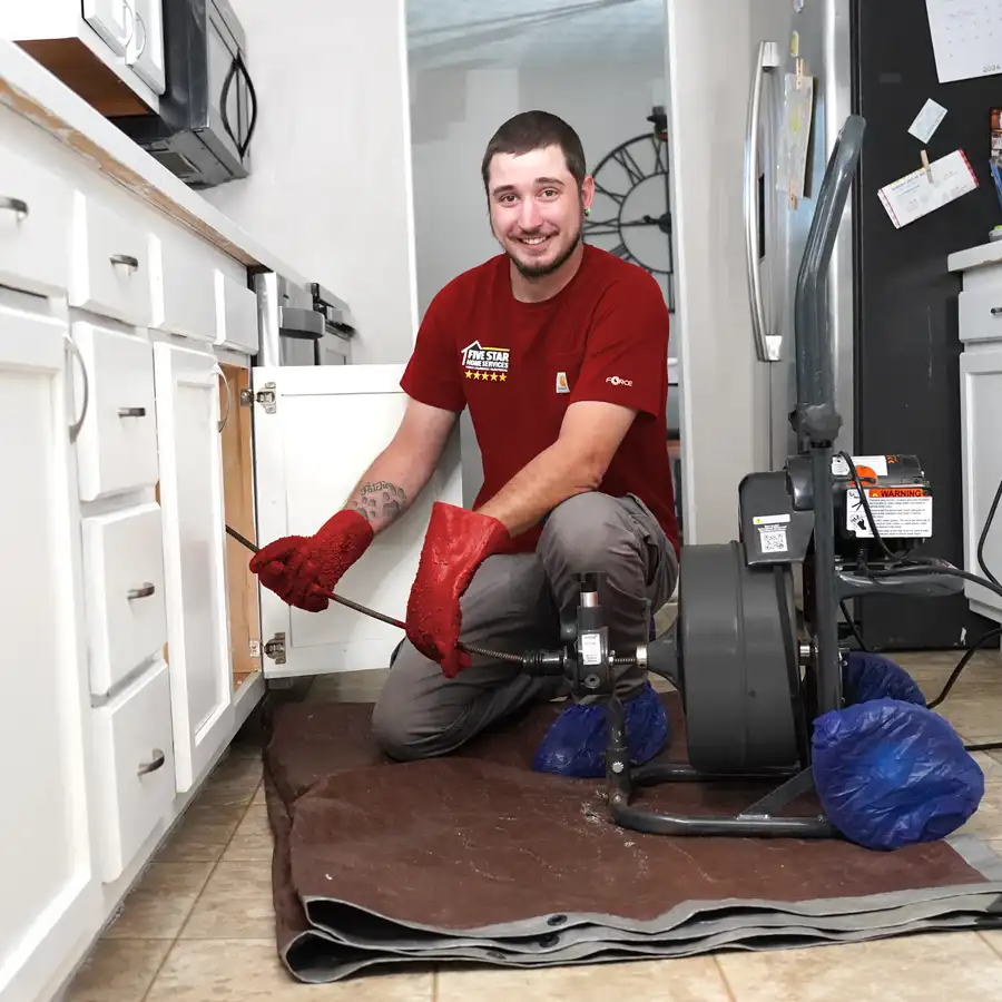 Plumber kneeling under a sink