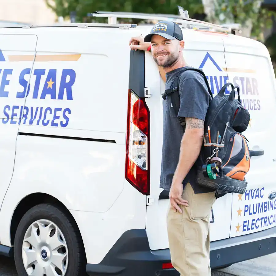 Plumber with tools stnading next to a van