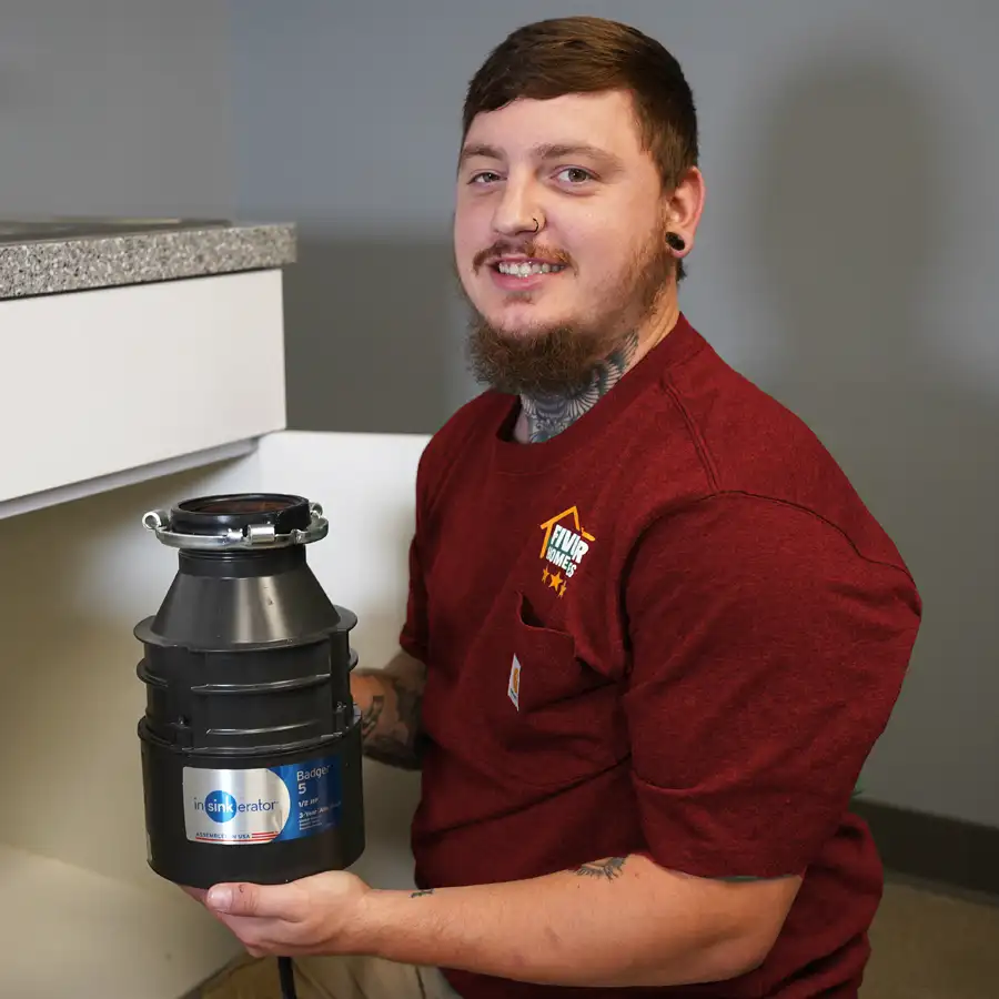 Plumber holding a new garbage disposal