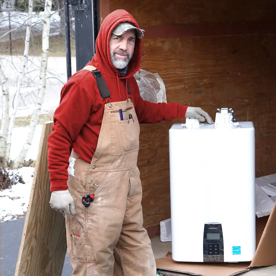 Plumber standing next to a tankless water heater