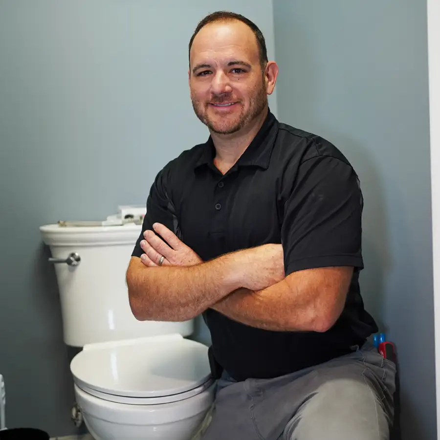 plumber sitting next to a toilet