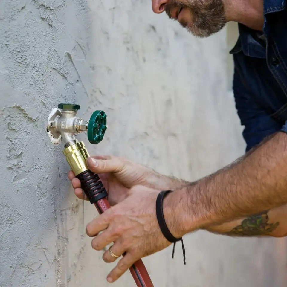 Plumber fixing a hose bib