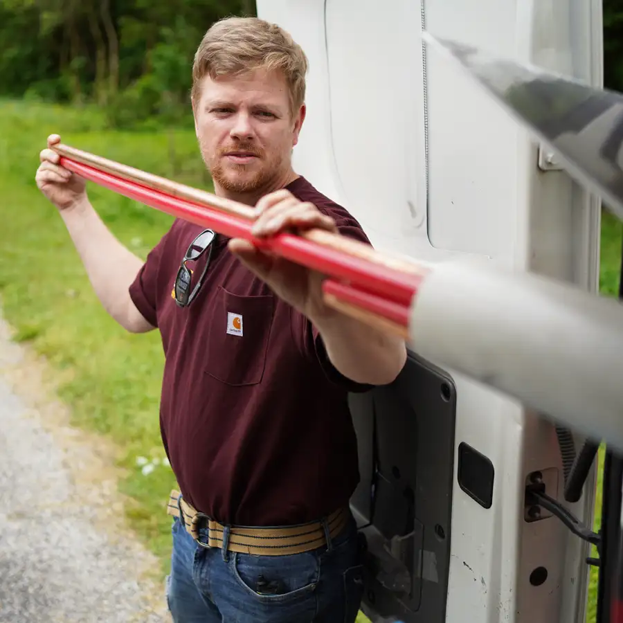 Plumber pulling piping from a van